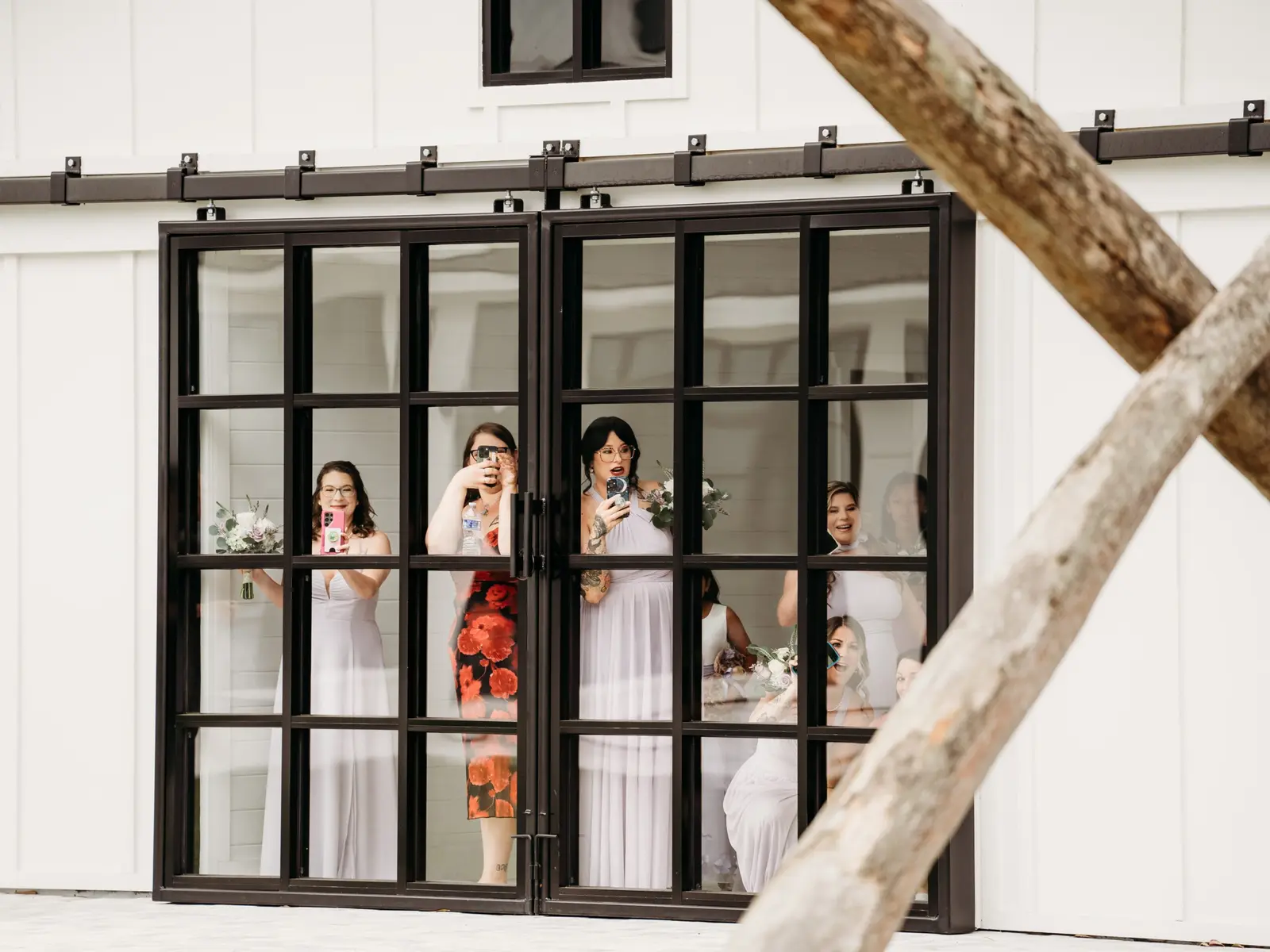 Bridal party looking out through the black-framed glass doors
